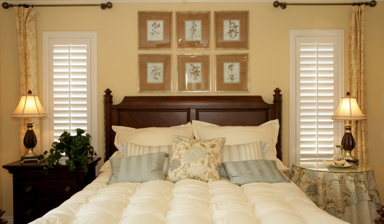 Beige bedroom with white plantation shutters covering windows in Honolulu 